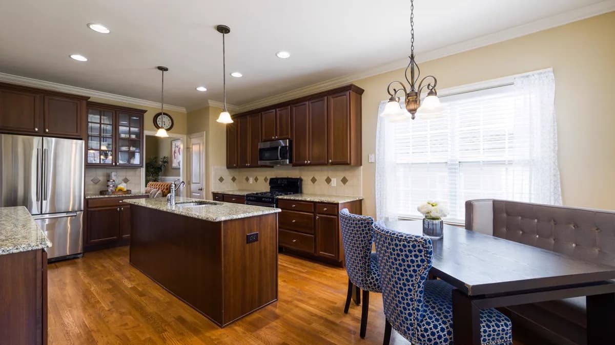 Completed kitchen with dark wood cabinets and granite counters